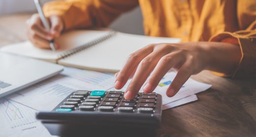 business person sitting at a desk at an office By using the calculator to work. Business Concept Analysis and Planning
