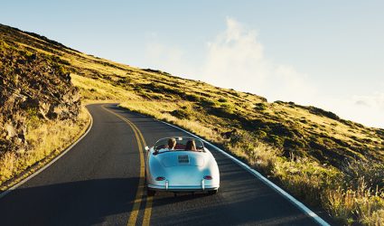 Happy Couple Driving on Country Road in Classic Vintage Sports Car