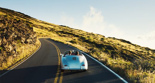 Happy Couple Driving on Country Road in Classic Vintage Sports Car